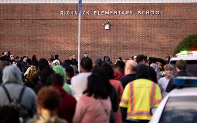Students and police gather outside of Richneck Elementary School after a shooting, Friday, Jan. 6, 2023 in Newport News, Va. (Billy Schuerman/The Virginian-Pilot via AP)