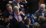 Republican Representative Richard Hudson of North Carolina, left, pulls Republican Representative Mike Rogers of Alabama, back as they talk with Republican Representative Matt Gaetz of Florida, and others during the 14th round of voting for speaker as the House meets for the fourth day to try and elect a speaker and convene the 118th Congress in Washington, January 6, 2023. (AP Photo/Andrew Harnik)