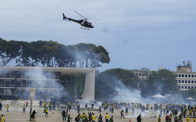 Protesters, supporters of Brazil's former President Jair Bolsonaro, clash with police as they storm the Planalto Palace in Brasilia, Brazil, Sunday, Jan. 8, 2023. (AP Photo/Eraldo Peres)