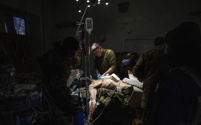 Ukrainian military doctors treat their injured comrade who was evacuated from the battlefield at the hospital in Donetsk region, Ukraine, January 9, 2023. The serviceman did not survive. (AP Photo/Evgeniy Maloletka)