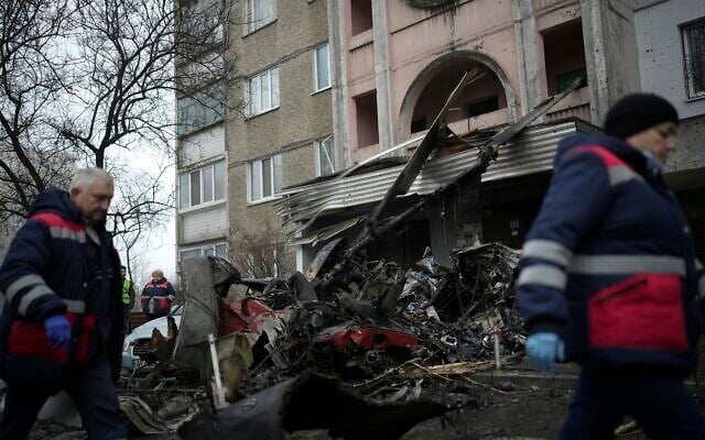 Workers pass the scene where a helicopter crashed on civil infrastructure in Brovary, on the outskirts of Kyiv, Ukraine, Wednesday, Jan. 18, 2023 (AP Photo/Daniel Cole) Workers pass the scene where a helicopter crashed on civil infrastructure in Brovary, on the outskirts of Kyiv, Ukraine, Wednesday, Jan. 18, 2023 (AP Photo/Daniel Cole)