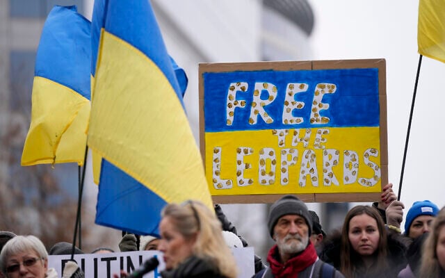 Protestors hold signs and wave Ukrainian flags during a demonstration in support of Ukraine outside of an EU foreign ministers meeting at the European Council building in Brussels on January 23, 2023. (AP Photo/Virginia Mayo)