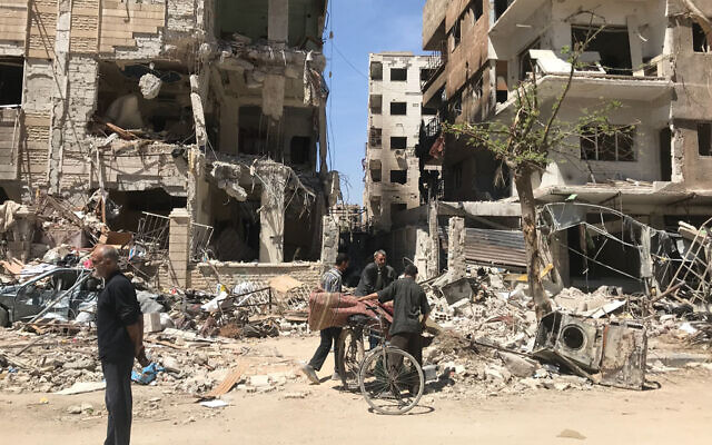 People stand in front of damaged buildings, in the town of Douma, the site of a suspected chemical weapons attack, near Damascus, Syria, Monday, April 16, 2018. (AP Photo/Hassan Ammar, File) People stand in front of damaged buildings, in the town of Douma, the site of a suspected chemical weapons attack, near Damascus, Syria, Monday, April 16, 2018. (AP Photo/Hassan Ammar, File)
