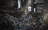 Cranes lift waste, mostly plastic and paper at the GreenNet recycling plant in Atarot industrial zone, north of Jerusalem, January 25, 2023. (Oded Balilty/AP)