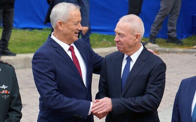 Outgoing defense minister Benny Gantz (left) embraces his successor Yoav Gallant, at military headquarters in Tel Aviv, January 1, 2023. (Emanuel Fabian/Times of Israel)