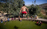 People enjoy a hot summer day at the Ein Lavan Spring in the Jerusalem Mountains, July 28, 2021. (Yonatan Sindel/Flash90)