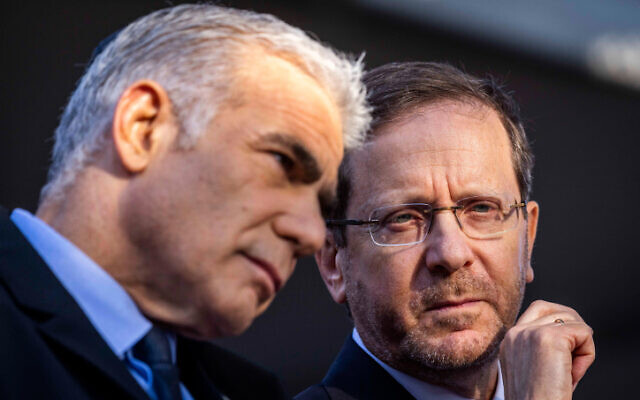 Then-prime minister Yair Lapid and President Isaac Herzog (left) at a memorial service marking 27 years since the assassination of prime minister Yitzhak Rabin, at Mount Herzl cemetery in Jerusalem on November 6, 2022. (Olivier Fitoussi/ Flash90) Then-prime minister Yair Lapid and President Isaac Herzog (left) at a memorial service marking 27 years since the assassination of prime minister Yitzhak Rabin, at Mount Herzl cemetery in Jerusalem on November 6, 2022. (Olivier Fitoussi/ Flash90)