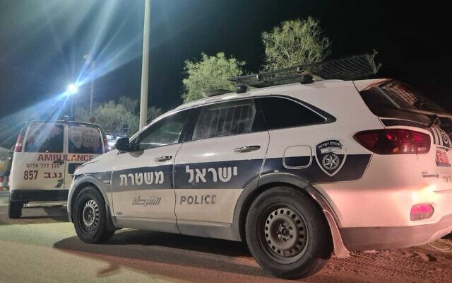 A handout photo from police shows a police cruiser and other emergency vehicles after a Bedouin man was shot dead in southern Israel, January 13, 2022. (Israel Police) A handout photo from police shows a police cruiser and other emergency vehicles after a Bedouin man was shot dead in southern Israel, January 13, 2022. (Israel Police)