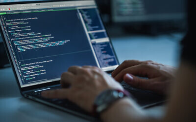 Illustrative: A man types on a computer keyboard as coding language is seen on the screen (gorodenkoff; iStock by Getty Images)