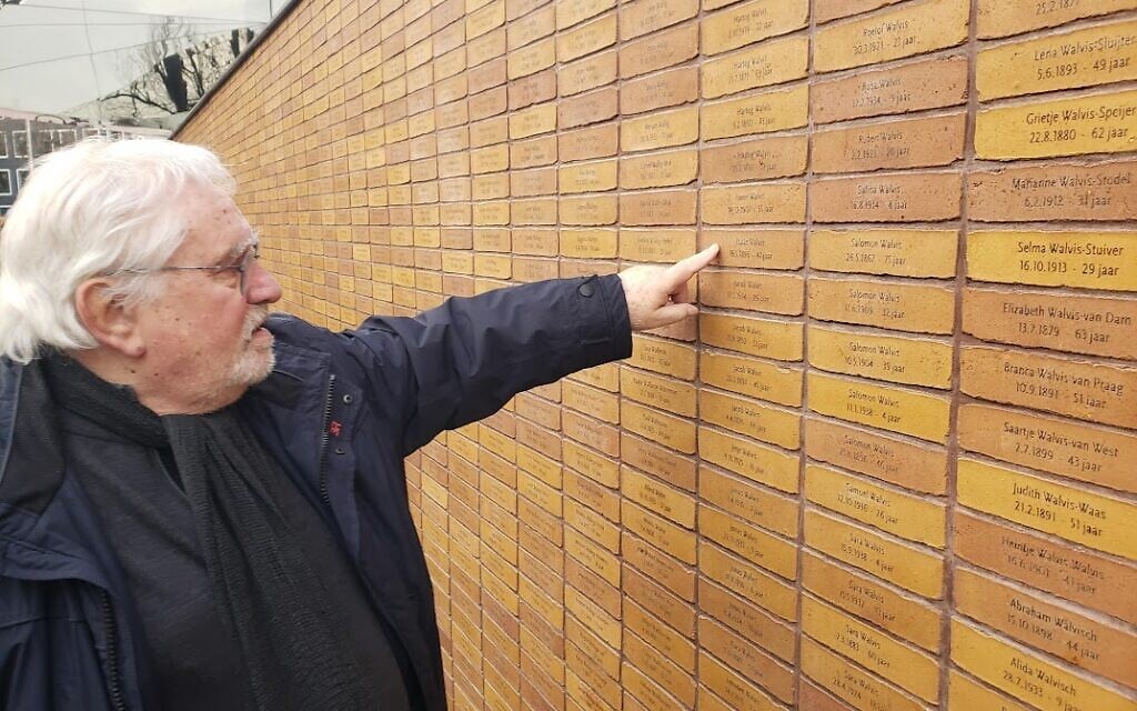 'Holocaust Namenmonument' founder Jacques Grishaver points to the names of aunts murdered in the Holocaust, Amsterdam, Dec. 27, 2022 (Matt Lebovic/The Times of Israel)