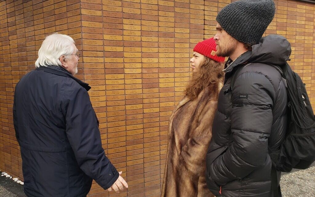 Memorial founder Jacques Grishaver and members of the public interact at the 'Namenmonument' in Amsterdam, with the names of Dutch-Jewish Holocaust victims, December 2022 (Matt Lebovic/The Times of Israel)