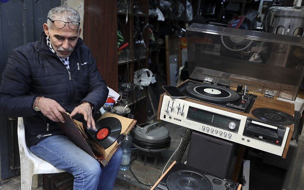 Jamal Hemmou checks a collection of vinyl records in front of his shop in the West Bank city of Nablus, January 17, 2023. (JAAFAR ASHTIYEH / AFP) Jamal Hemmou checks a collection of vinyl records in front of his shop in the West Bank city of Nablus, January 17, 2023. (JAAFAR ASHTIYEH / AFP)