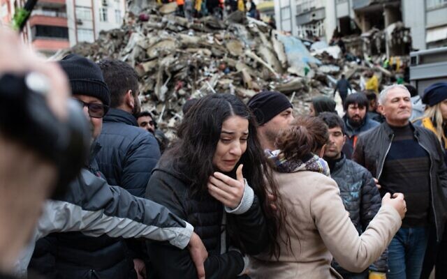 A woman reacts as rescuers search for survivors through the rubble of collapsed buildings in Adana, on February 6, 2023 after a 7,8 magnitude earthquake struck the country's south-east (Can EROK / AFP)