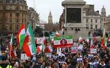 Opposition protesters hold up placards after a march marking the 44th anniversary of Iranian Revolution, in Trafalgar Square, central London on February 11, 2023. (Susannah Ireland/AFP)