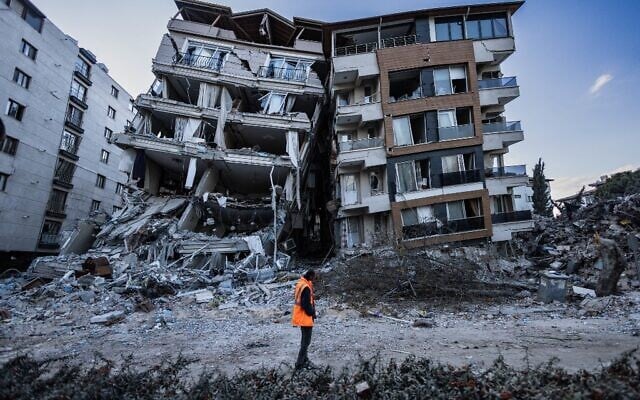 A rescue worker walks past partially collapsed buildings in the city of Antakya on February 19, 2023. (Sameer Al-Doumy/AFP) A rescue worker walks past partially collapsed buildings in the city of Antakya on February 19, 2023. (Sameer Al-Doumy/AFP)