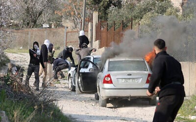 Israeli settlers hurl stones and set fire to cars in the village of Burin, in the northern West Bank on February 25, 2023. (Jaafar ASHTIYEH / AFP)