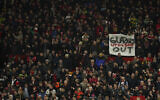 An anti-Glazer family banner is held up by members of the crowd before the English League Cup semifinal second leg soccer match between Manchester United and Nottingham Forest at Old Trafford in Manchester, England, Wednesday, February 1, 2023. (AP Photo/Dave Thompson)