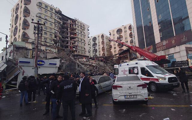 Rescue workers and medical teams try to reach trapped residents in a collapsed building following and earthquake in Diyarbakir, southeastern Turkey, early Monday, Feb. 6, 2023. (AP Photo/Mahmut Bozarsan)