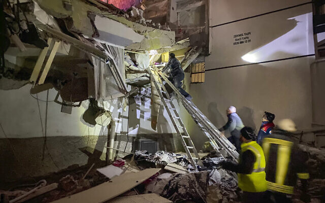 Rescue teams try to reach trapped residents inside collapsed buildings in Adana, Turkey, Feb. 6, 2023. (IHA agency via AP)