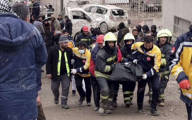 Firefighters carry the body of a victim in Diyarbakir, in southeastern Turkey, after an earthquake, Feb. 6, 2023. (AP Photo/Mahmut Bozarsan)