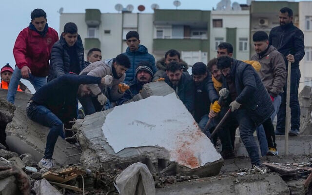 Men search for people among the debris in a destroyed building in Adana, Turkey, February 6, 2023. (AP Photo/Khalil Hamra) Men search for people among the debris in a destroyed building in Adana, Turkey, February 6, 2023. (AP Photo/Khalil Hamra)