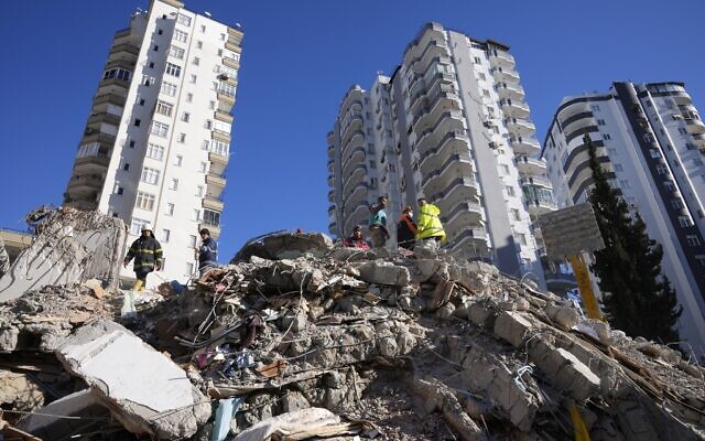 Emergency teams search for people in the rubble of a destroyed building in Adana, southern Turkey, Feb. 7, 2023 (AP Photo/Hussein Malla)