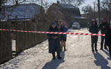 Residents wait behind a police cordon to return to their homes after a rocket attack in Kyiv, Ukraine, February 10, 2023. (AP Photo/Emilio Morenatti)