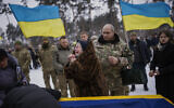 Nina Nikiforovа, 80, cries next to the body of her son Oleg Kunynets, a Ukrainian military serviceman who was killed in the east of the country, during his funeral in Kyiv, Ukraine, Feb. 11, 2023. (AP Photo/Emilio Morenatti)