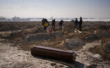 Municipal grave diggers bury the bodies of four people, three of the them not claimed by relatives, in a makeshift cemetery on the outskirts of Elbistan, Turkey, February 11, 2023, following an earthquake that devastated the area. (AP Photo/Francisco Seco)