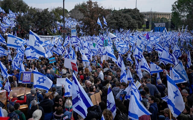 Israelis wave national flags at a rally against the judicial overhaul, outside the Knesset in Jerusalem, February 13, 2023. (AP Photo/Ohad Zwigenberg) Israelis wave national flags at a rally against the judicial overhaul, outside the Knesset in Jerusalem, February 13, 2023. (AP Photo/Ohad Zwigenberg)