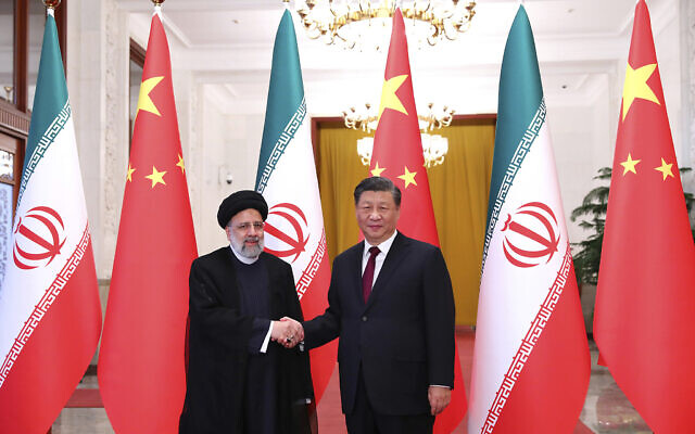 In this photo released by the official website of the office of the Iranian Presidency, President Ebrahim Raisi, left, shakes hands with his Chinese counterpart Xi Jinping in an official welcoming ceremony in Beijing, Tuesday, Feb. 14, 2023. (Iranian Presidency Office via AP)