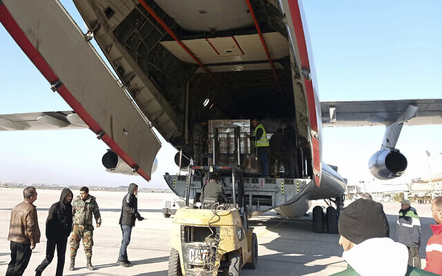 Workers unload humanitarian aid sent from Saudi Arabia for Syria following a devastating earthquake, at the airport in Aleppo, Syria, February 14, 2023. (SANA via AP)