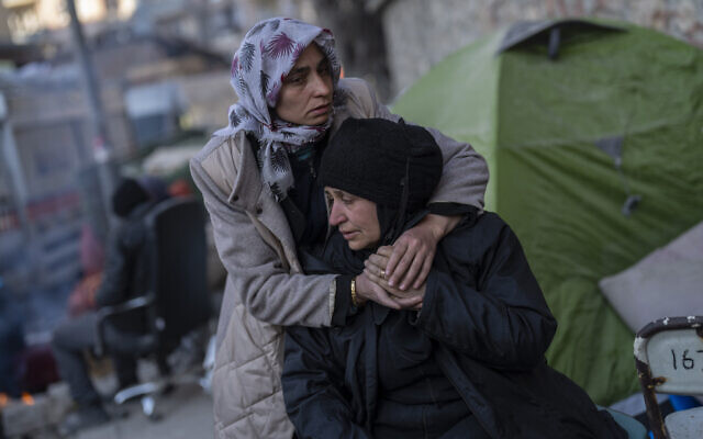 A family mourns moments after a body of a relative was pulled out of a building destroyed during the earthquake in Antakya, southeastern Turkey, February 14, 2023. (Bernat Armangue/AP)