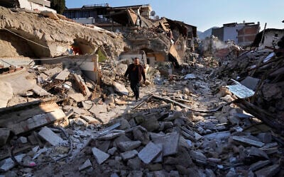 A Turkish man, walks on the debris of the heritage houses that destroyed during the devastated earthquake, in the old city of Antakya, southern Turkey, Monday, February 13, 2023. (AP/Hussein Malla)