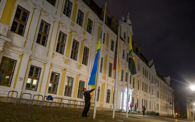 A policeman raises the flag of Ukraine in front of the state parliament of Saxony-Anhalt in Magdeburg, Germany February 24, 2023. (Klaus-Dietmar Gabbert/dpa via AP) A policeman raises the flag of Ukraine in front of the state parliament of Saxony-Anhalt in Magdeburg, Germany February 24, 2023. (Klaus-Dietmar Gabbert/dpa via AP)