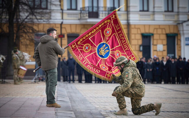 Ukrainian President Volodymyr Zelensky, left, holds the flag of a military unit as an officer kisses it, during a commemorative event on the occasion of the one year anniversary of the Russia Ukraine war in Kyiv, Ukraine, February 24, 2023. (Ukrainian Presidential Press Office via AP) Ukrainian President Volodymyr Zelensky, left, holds the flag of a military unit as an officer kisses it, during a commemorative event on the occasion of the one year anniversary of the Russia Ukraine war in Kyiv, Ukraine, February 24, 2023. (Ukrainian Presidential Press Office via AP)