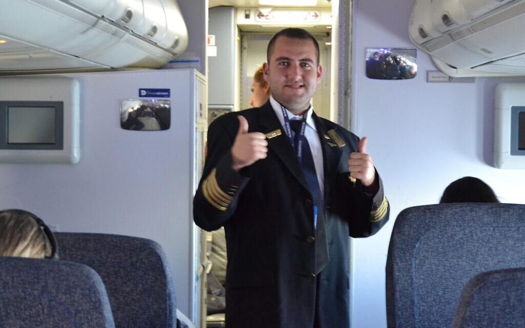 Idan Fishslevich, a 22-year-old with high functioning ASD who was made a flight attendant for a day, is seen onboard an El Al plane before departing to Rome, Italy, February 20, 2023. (Tobias Siegal/Times of Israel)