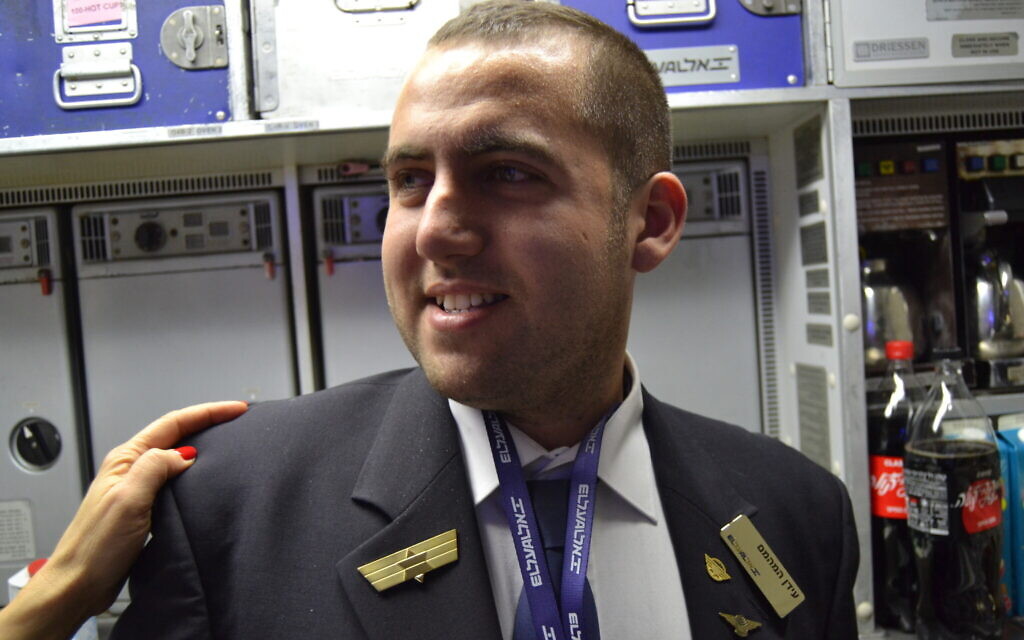 Idan Fishslevich, a 22-year-old with high functioning ASD who was made a flight attendant for one day, is seen onboard El Al's flight LY383 to Rome, Italy, February 20, 2023. (Tobias Siegal/The Times of Israel)