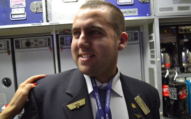 Idan Fishslevich, a 22-year-old with high functioning ASD who was made a flight attendant for one day, is seen onboard El Al's flight LY383 to Rome, Italy, February 20, 2023. (Tobias Siegal/The Times of Israel)