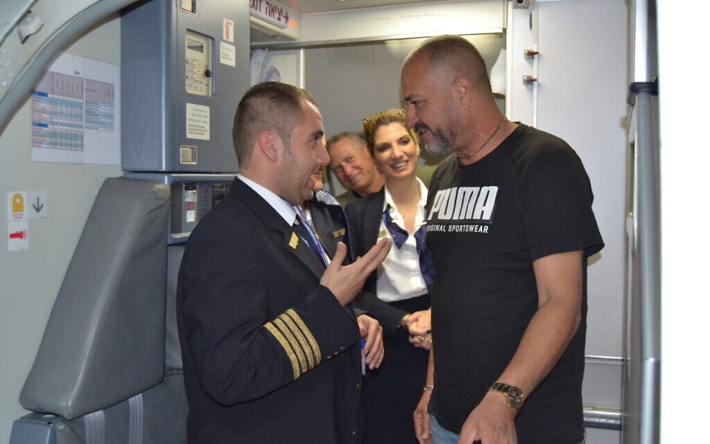 A passenger thanks Idan Fishslevich, a 22-year-old with high functioning ASD who was made a flight attendant for one day, after landing in Rome, Italy, February 20, 2023. (Tobias Siegal/The Times of Israel)
