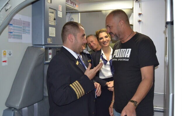 A passenger thanks Idan Fishslevich, a 22-year-old with high functioning ASD who was made a flight attendant for one day, after landing in Rome, Italy, February 20, 2023. (Tobias Siegal/The Times of Israel)