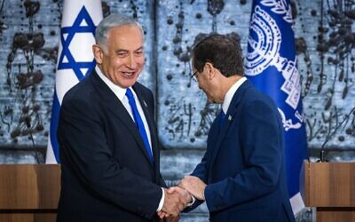 President Isaac Herzog (right) shakes hands with Benjamin Netanyahu after presenting the Likud leader with a mandate to form a new government, at the President's Residence in Jerusalem on November 13, 2022. (Olivier Fitoussi/Flash90)