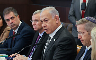 Prime Minister Benjamin Netanyahu, with Justice Minister Yariv Levin at his side, chairs the weekly cabinet meeting in Jerusalem, Feb. 12, 2023. (Amit Shabi / Pool)