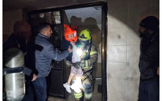 Firefighters evacuate residents from a building on fire in Beersheba on February 8, 2023. (Fire and Rescue Service)