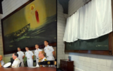 A before and after photo depicting how a painting of Jesus at the U.S. Merchant Marine Academy in Kings Point, New York, had been obscured by a curtain. (Before: U.S. Coast Guard; After: U.S. Merchant Marine Academy.)