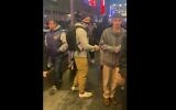 A person identified with the National Socialist Movement, a neo-Nazi group headquartered in Florida that has a swastika in its logo, carrying a poster that accuses Leo Frank of being a pedophile outside a Broadway theater that is hosting the play 'Parade,' February 21, 2023. (Screenshot from Twitter, used in accordance with Clause 27a of the Copyright Law)
