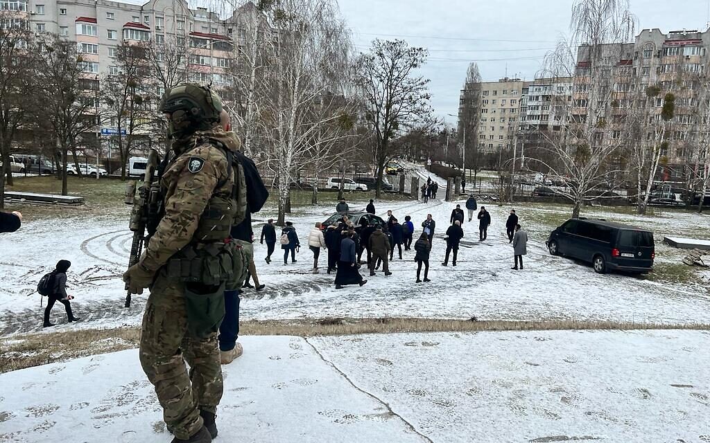 A Ukrainian soldier keeps an eye on Foreign Minister Eli Cohen's visit to Bucha, Ukraine, February 16, 2023 (Lazar Berman/The Times of Israel)