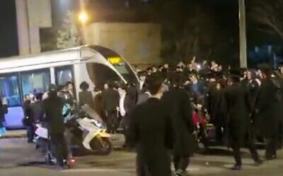 Haredi protesters blocking a light rail train in Jerusalem on February 21, 2023. (screen capture: Twitter/Yair Levy; Used in accordance with Clause 27a of the Copyright Law)