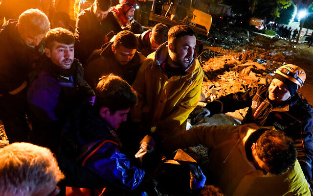 Rescuers carry the body of a person found in the rubble of a destroyed building in Adana, Turkey, February 6, 2023. (AP Photo/Khalil Hamra) Rescuers carry the body of a person found in the rubble of a destroyed building in Adana, Turkey, February 6, 2023. (AP Photo/Khalil Hamra)