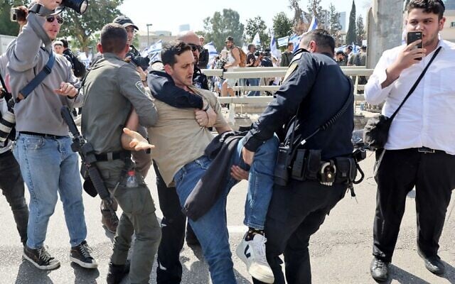 Israeli police officers detain a protester during a demonstration against the government's controversial justice overhaul in Tel Aviv on March 1, 2023. (JACK GUEZ / AFP) Israeli police officers detain a protester during a demonstration against the government's controversial justice overhaul in Tel Aviv on March 1, 2023. (JACK GUEZ / AFP)